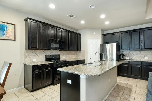 a kitchen with stainless steel appliances granite countertop a stove sink microwave and refrigerator