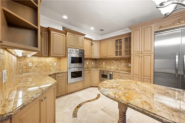 a kitchen with kitchen island granite countertop a sink a counter top space and stainless steel appliances