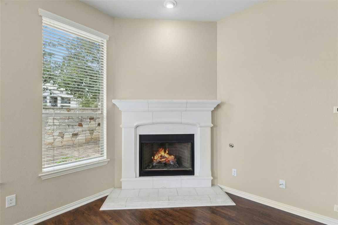 2804 Prosperity Leander, TX 78641 - Photo 13 of 39 Detailed view of wood finished floors, a lit fireplace, and baseboards