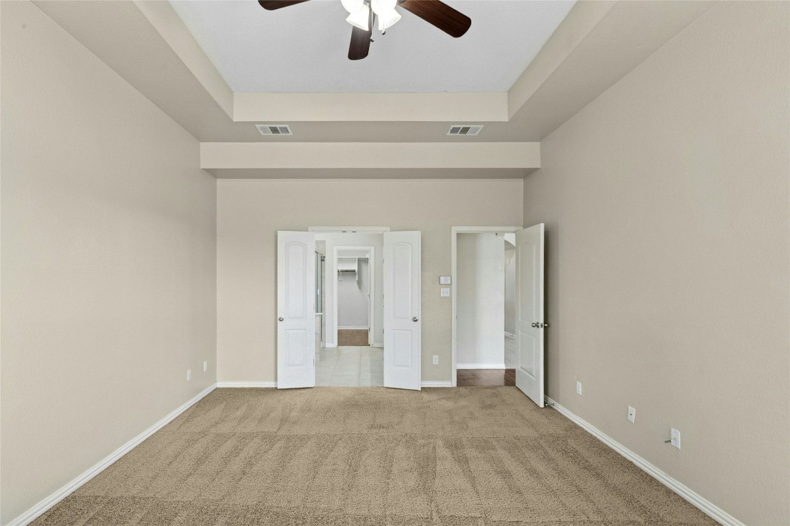 2804 Prosperity Leander, TX 78641 - Photo 17 of 39 Unfurnished bedroom featuring carpet, baseboards, a tray ceiling, and ceiling fan