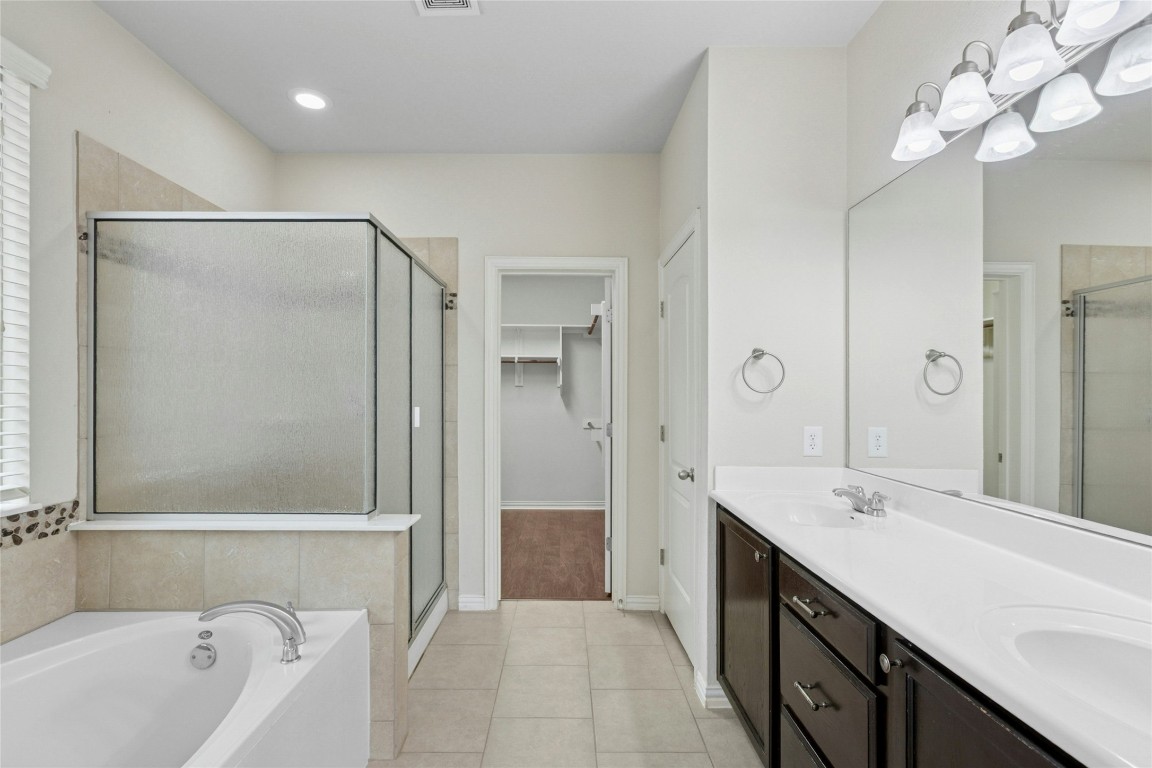 2804 Prosperity Leander, TX 78641 - Photo 20 of 39 Full bath featuring a stall shower, double vanity, a bath, tile patterned flooring, and a walk in closet