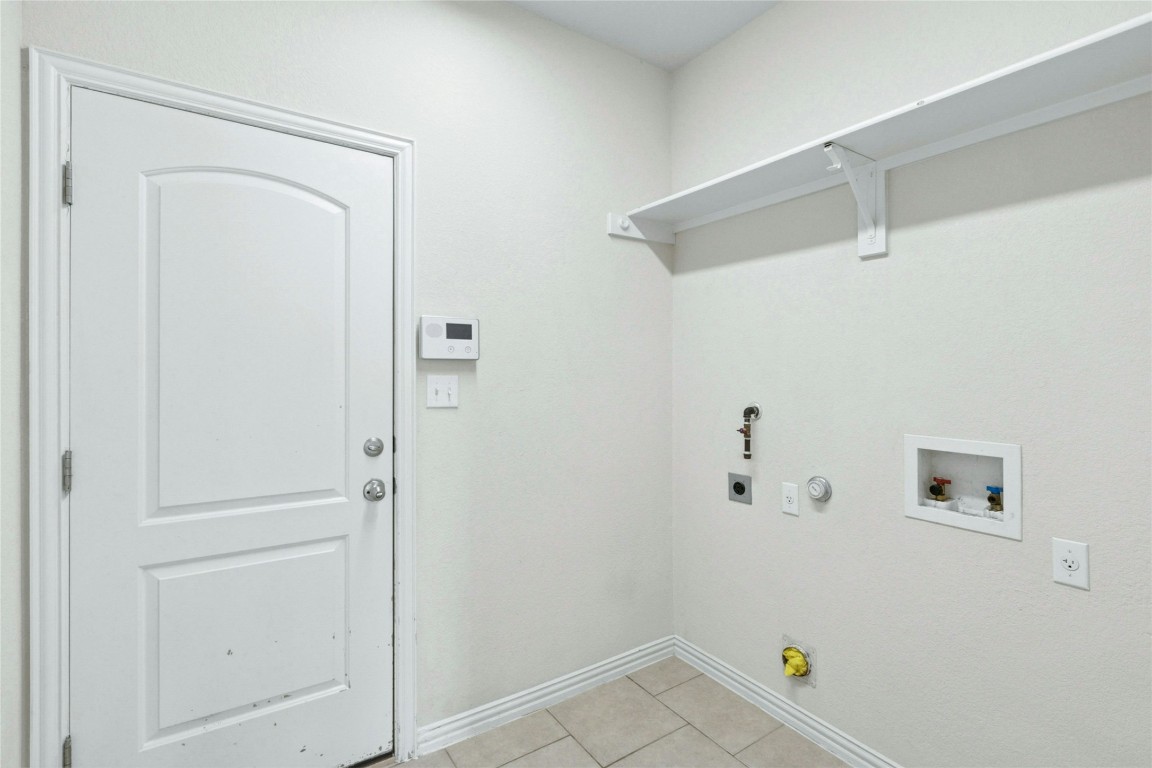 2804 Prosperity Leander, TX 78641 - Photo 21 of 39 Washroom featuring hookup for a gas dryer, electric dryer hookup, baseboards, hookup for a washing machine, and light tile patterned floors