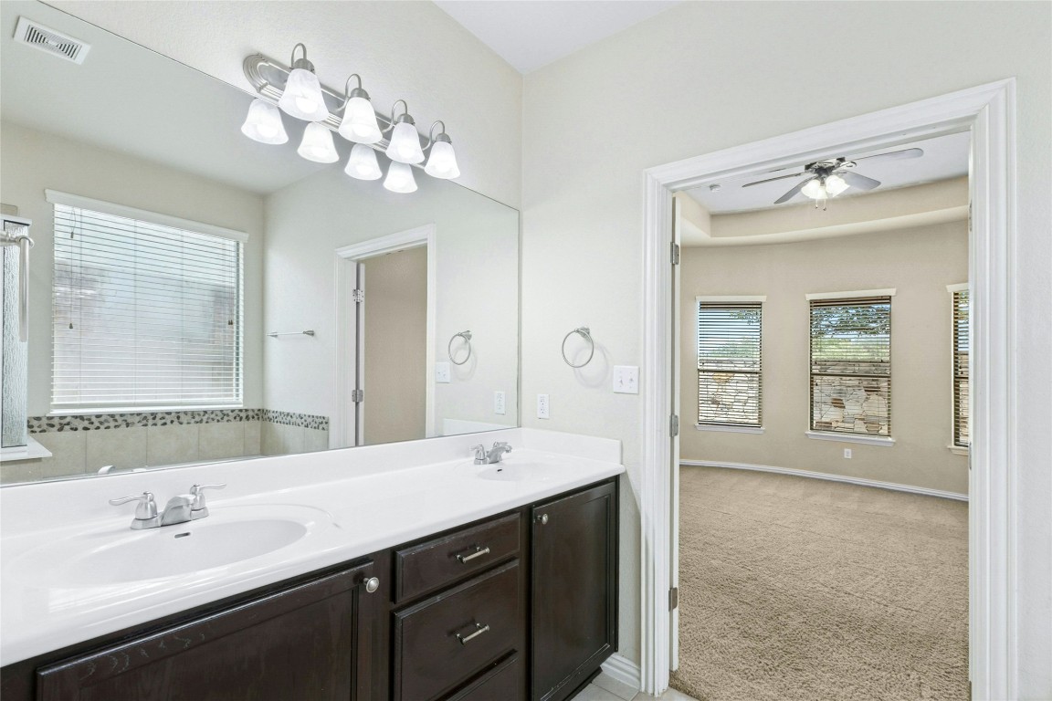 2804 Prosperity Leander, TX 78641 - Photo 28 of 39 Full bath with double vanity, ceiling fan, and baseboards