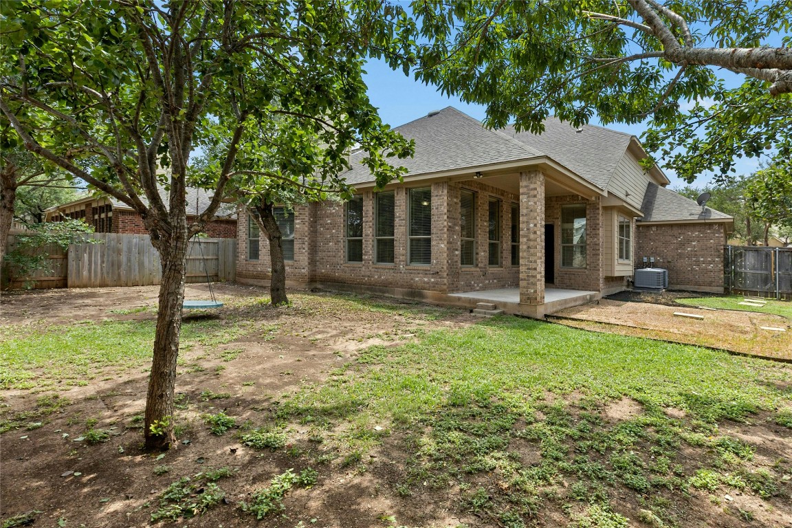 2804 Prosperity Leander, TX 78641 - Photo 36 of 39 Back of house featuring roof with shingles, brick siding, a patio area, and central AC