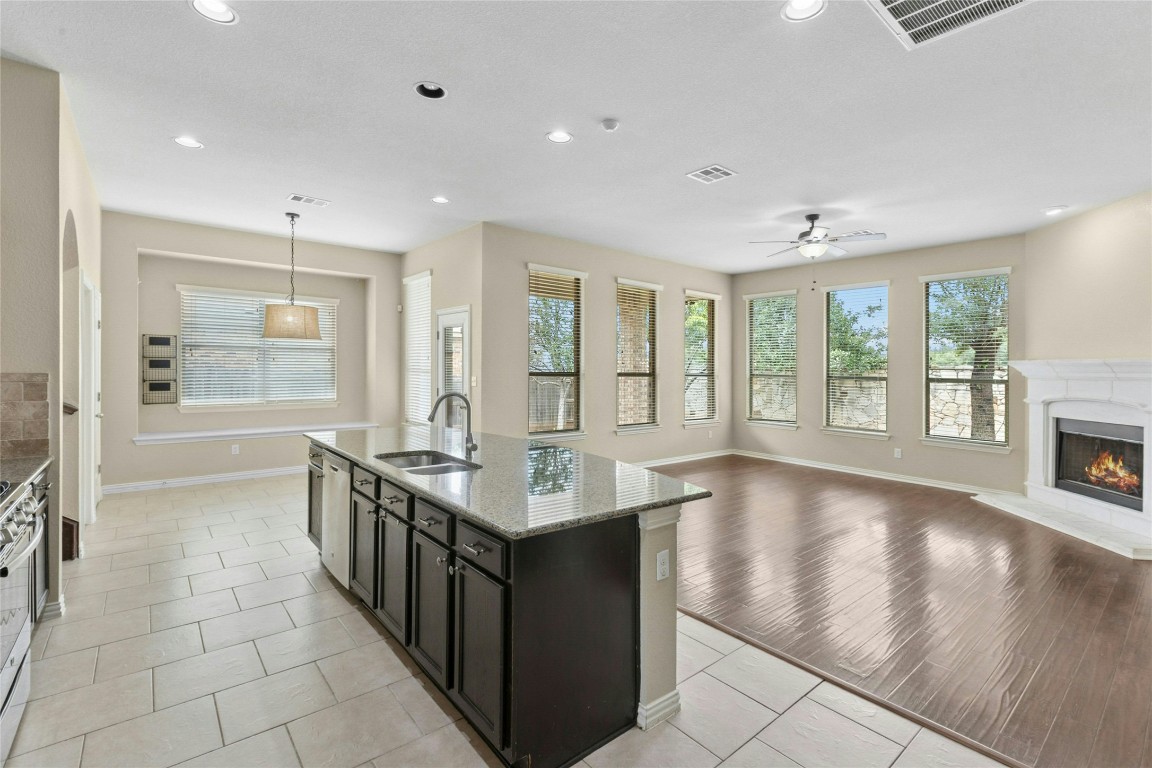 2804 Prosperity Leander, TX 78641 - Photo 39 of 39 Kitchen featuring a sink, open floor plan, baseboards, a high end fireplace, and recessed lighting