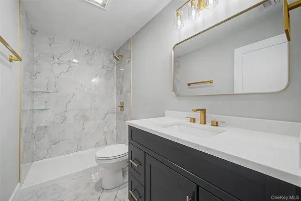 a bathroom with a sink a toilet and shower