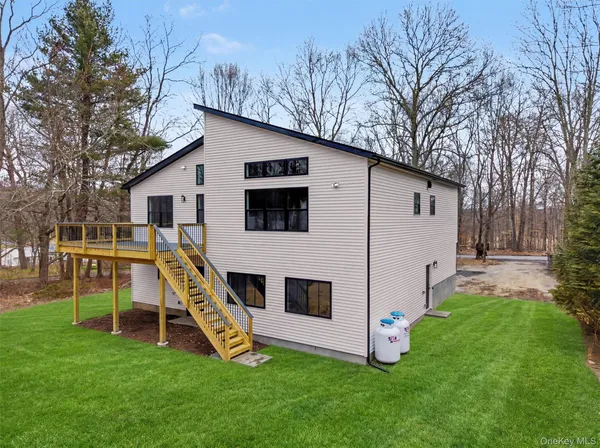 a view of a house with a yard and deck
