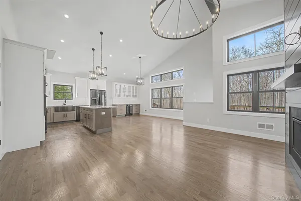 a view of a living room and kitchen with furniture wooden floor and windows