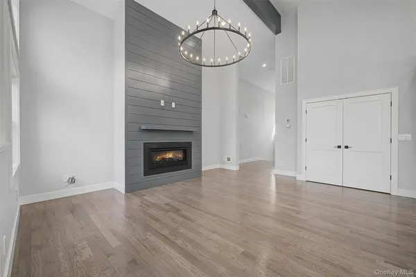 a view of empty room with wooden floor and fireplace