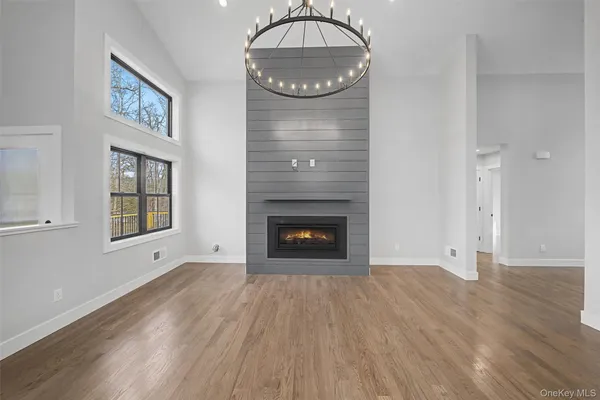 a view of a livingroom with wooden floor a fireplace and window