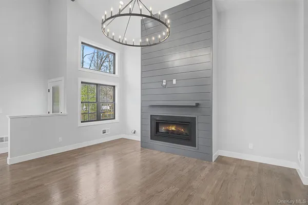 a view of an empty room with a fireplace and wooden floor