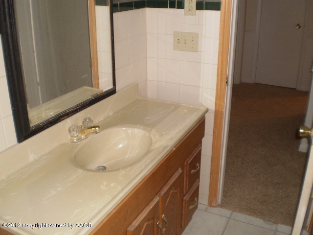6202 Calumet Road Amarillo, TX 79106 - Photo 11 of 13 a bathroom with a sink and a mirror
