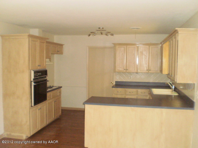 6202 Calumet Road Amarillo, TX 79106 - Photo 3 of 13 a kitchen with a refrigerator and a sink