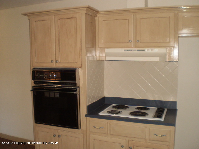 6202 Calumet Road Amarillo, TX 79106 - Photo 4 of 13 a kitchen with granite countertop white cabinets and black appliances