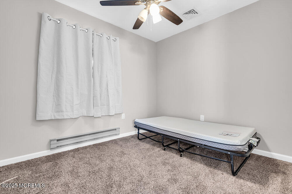 69 D Sunset Road, Unit 60 Whiting, NJ 08759 - Photo 13 of 19 a room with a bed and a ceiling fan