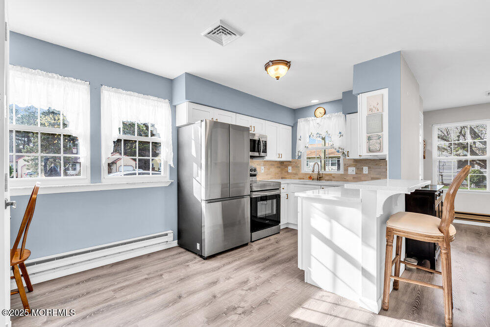 69 D Sunset Road, Unit 60 Whiting, NJ 08759 - Photo 7 of 19 a kitchen with refrigerator cabinets and wooden floor