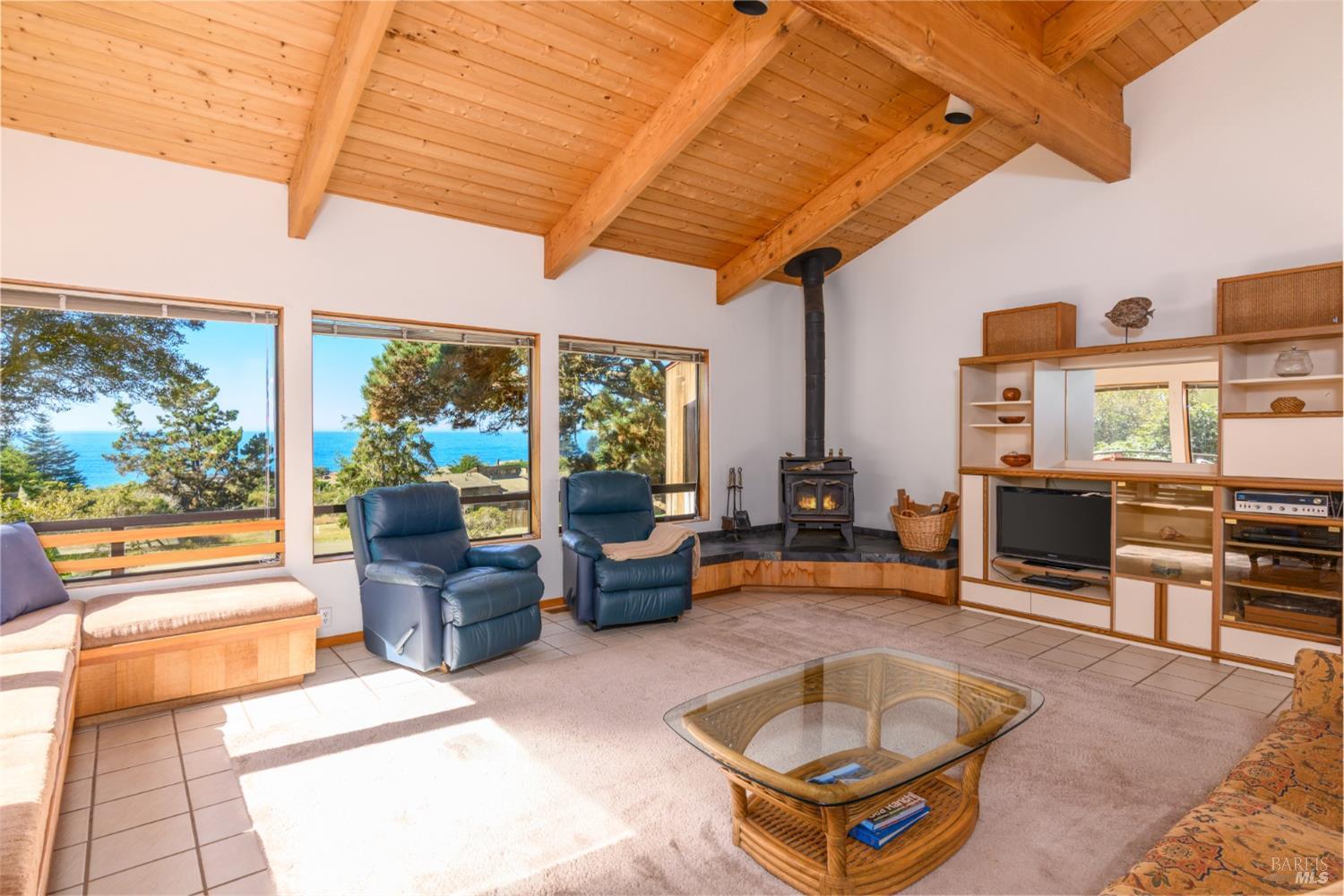 a living room with furniture a fireplace and large windows