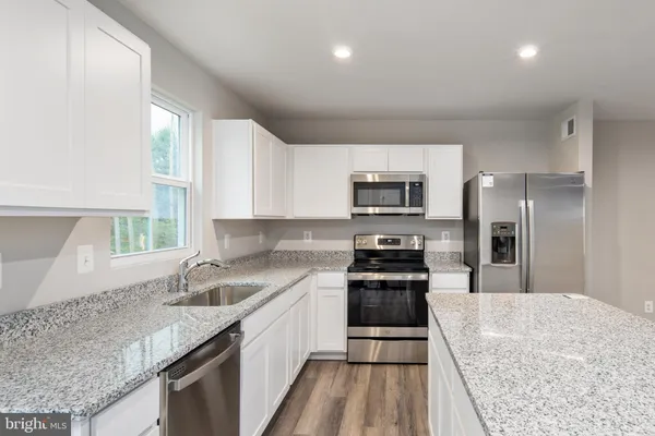 a kitchen with a sink stove top oven and refrigerator