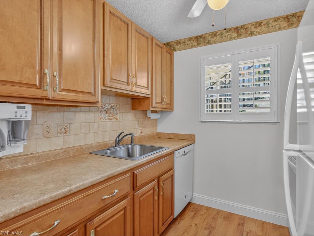 766 Central Avenue, Unit 101 Naples, FL 34102 - Photo 8 of 19 a kitchen with stainless steel appliances granite countertop a sink and a white cabinets