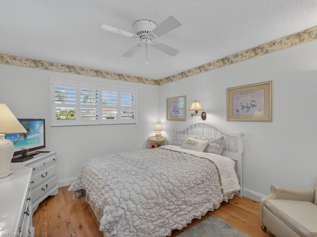 766 Central Avenue, Unit 101 Naples, FL 34102 - Photo 10 of 19 a bedroom with a bed and a couch