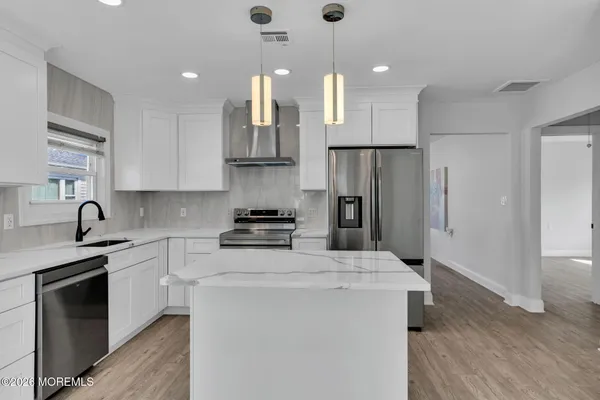 a kitchen with stainless steel appliances a refrigerator sink and cabinets
