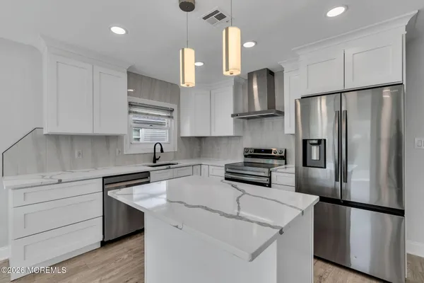 a kitchen with stainless steel appliances a refrigerator sink and cabinets