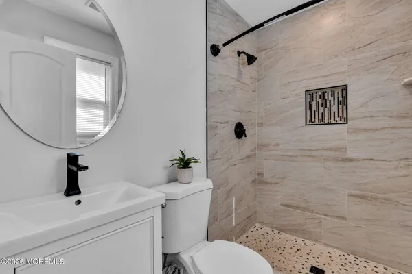 a bathroom with a toilet sink a mirror and vanity