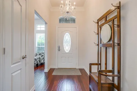 a view of a hallway with wooden floor and entryway