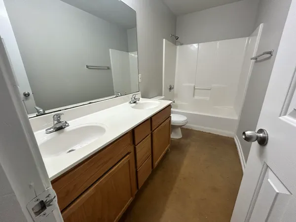 a bathroom with a double vanity sink toilet mirror and bathtub