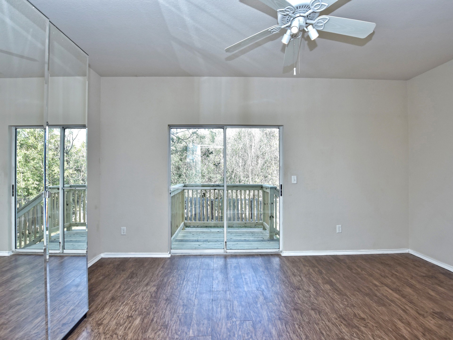 917 East 3rd Street Georgetown, TX 78626 - Photo 9 of 23 Hardwood floors and a private balcony enhance this inviting bedroom, offering a serene escape.