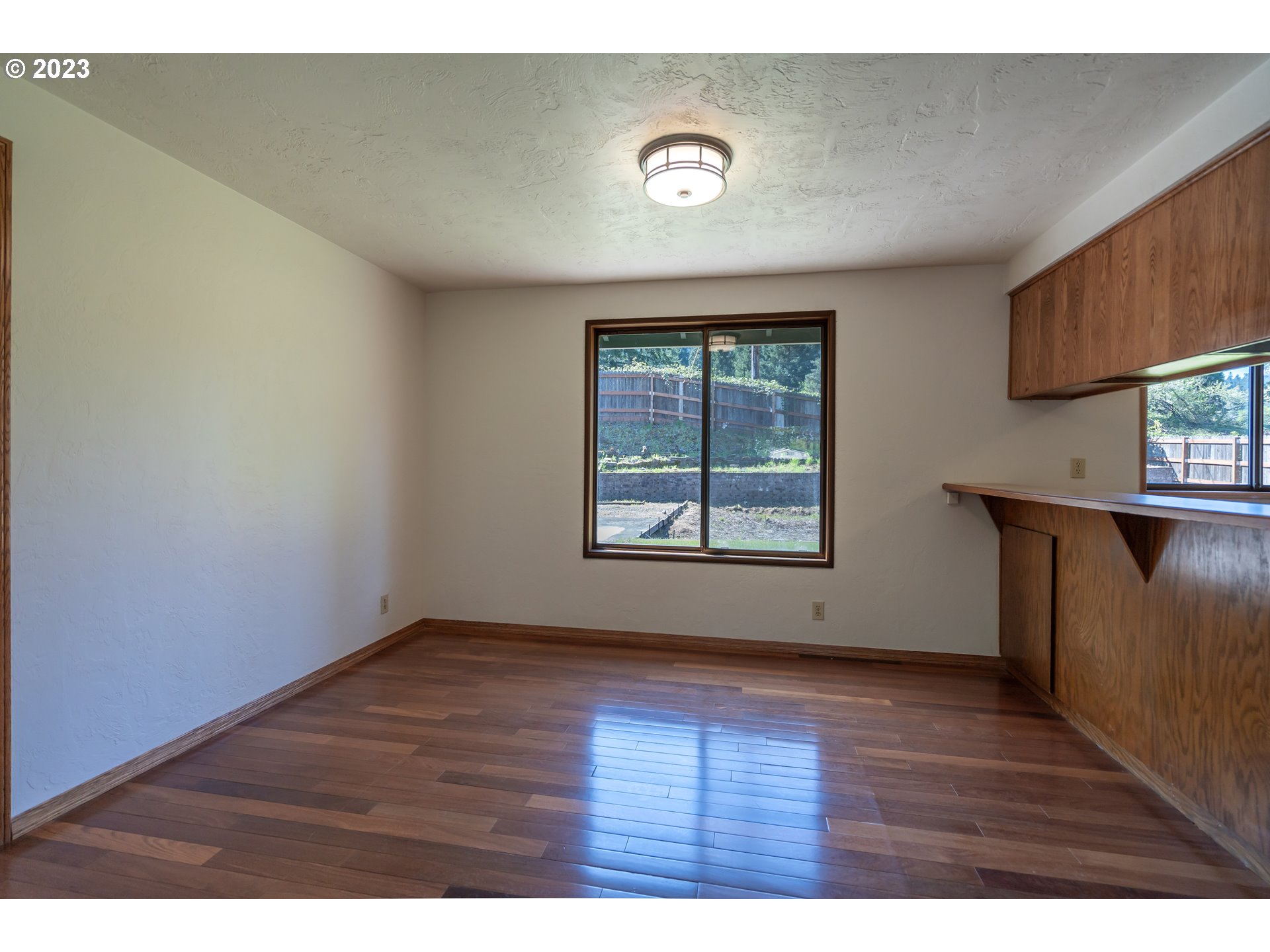 7441 A Street Springfield, OR 97478 - Photo 6 of 25 a view of an empty room with wooden floor and a window