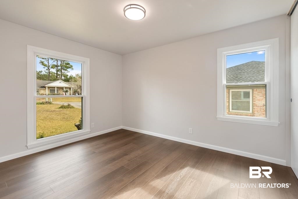 554 Stuart Street Daphne, AL 36526 - Photo 14 of 49 Unfurnished room with a healthy amount of sunlight and dark hardwood / wood-style flooring