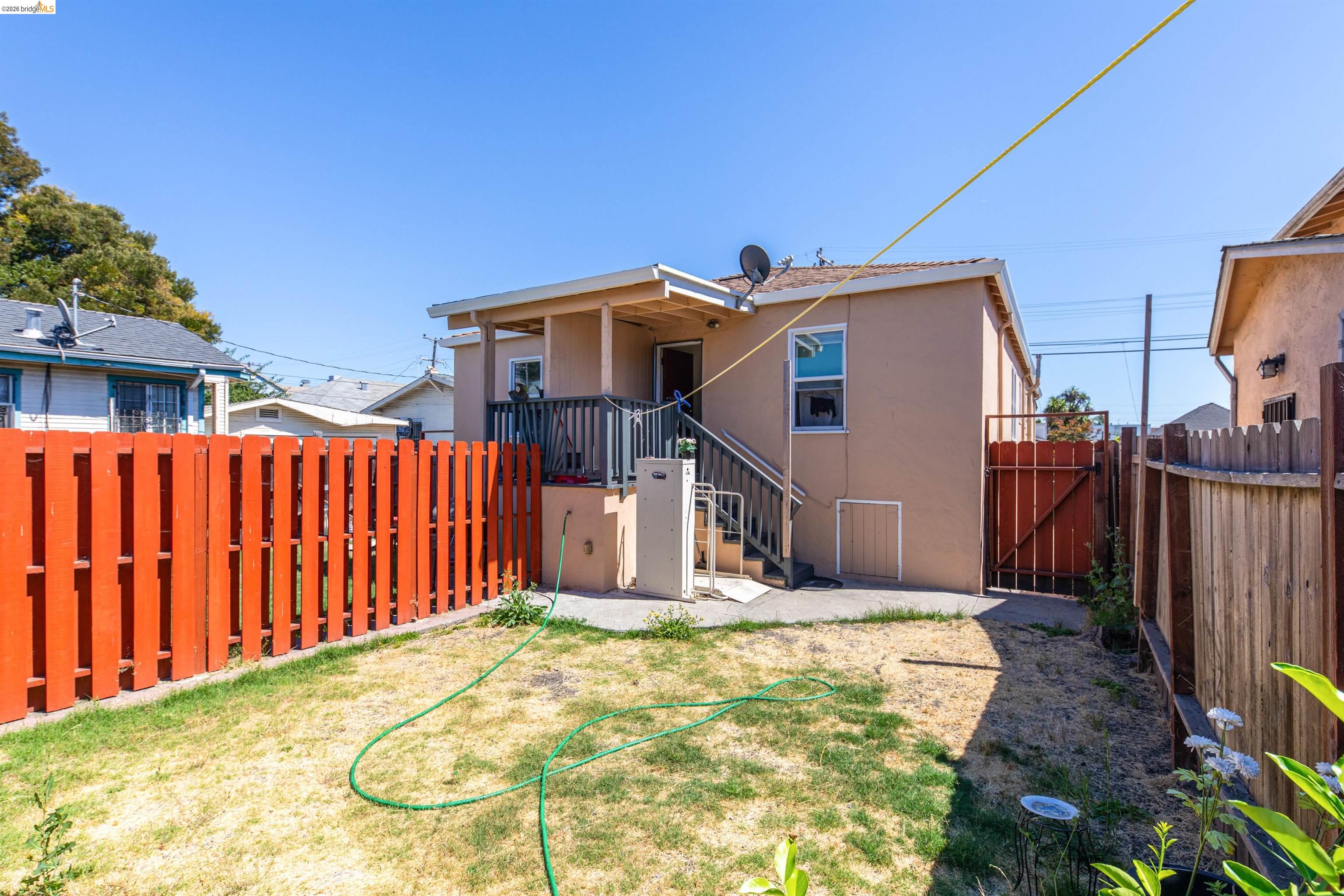 1821 74th Avenue Oakland, CA 94621 - Photo 12 of 27 Rear view of property with stucco siding, a fenced backyard, a patio, a gate, and stairway