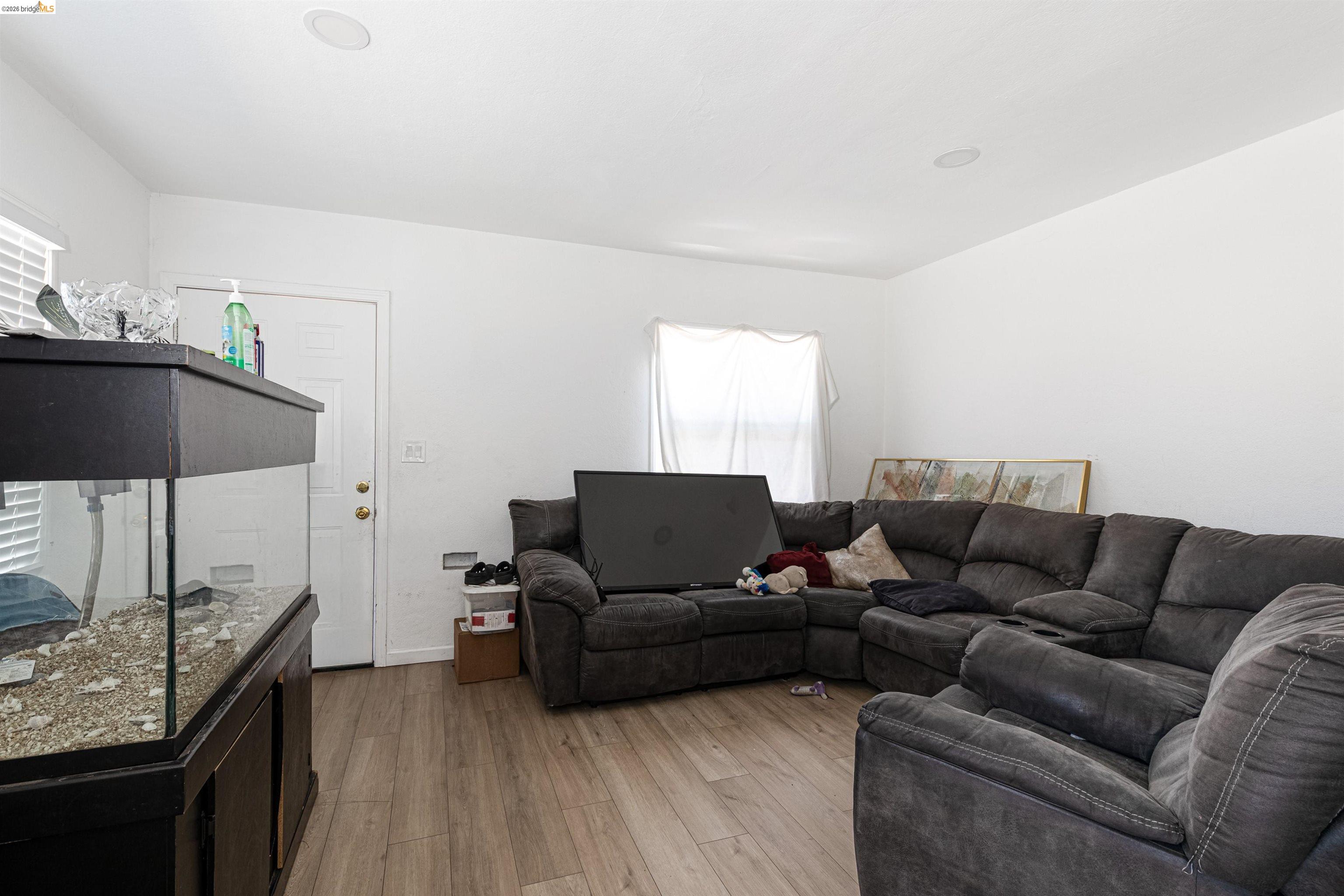 1821 74th Avenue Oakland, CA 94621 - Photo 16 of 27 Living room with light wood-style flooring and baseboards