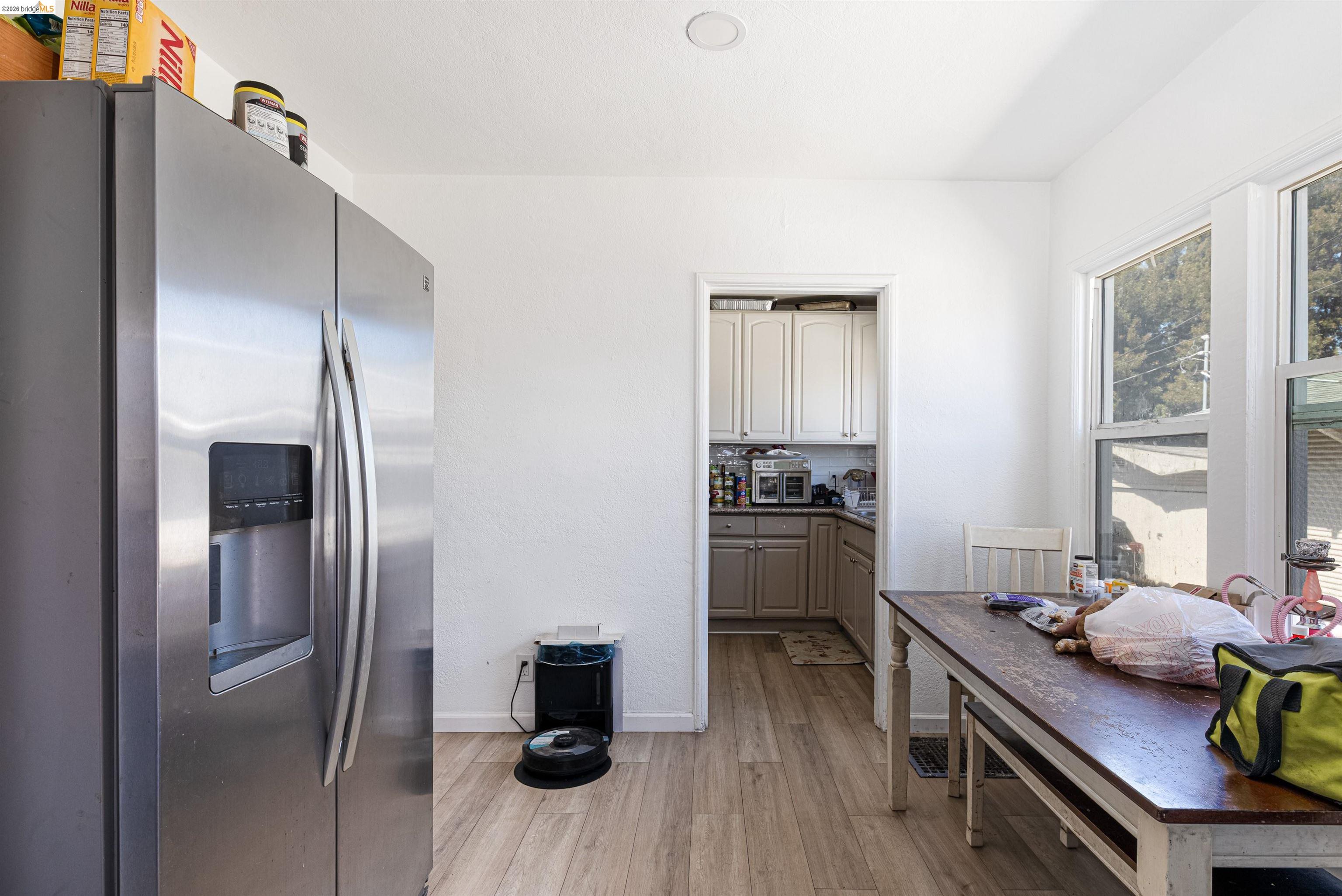 1821 74th Avenue Oakland, CA 94621 - Photo 18 of 27 Kitchen with stainless steel refrigerator with ice dispenser and light wood-style floors
