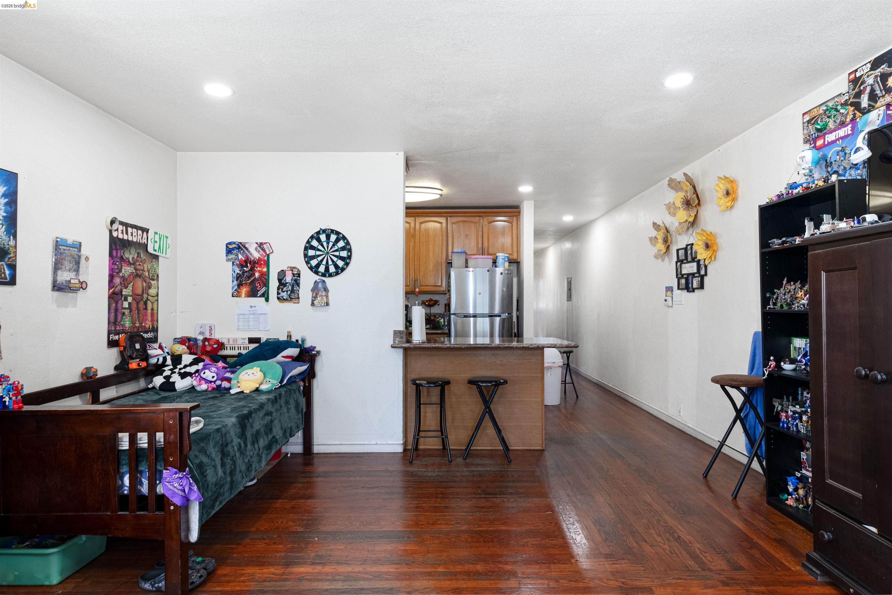 1821 74th Avenue Oakland, CA 94621 - Photo 3 of 27 Bedroom featuring dark wood-style floors, freestanding refrigerator, and recessed lighting
