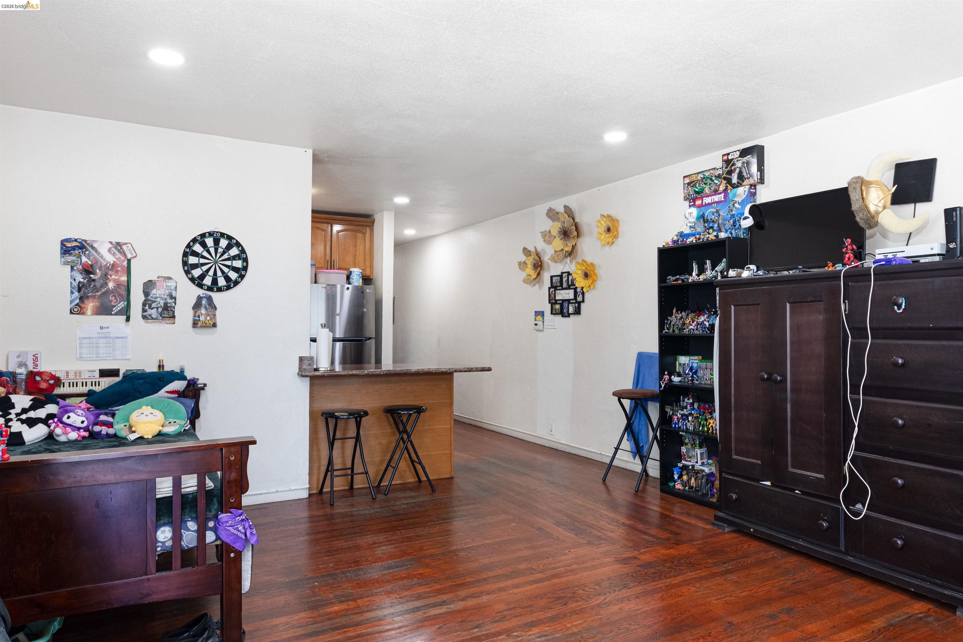 1821 74th Avenue Oakland, CA 94621 - Photo 4 of 27 Bedroom with freestanding refrigerator, dark wood-type flooring, and recessed lighting