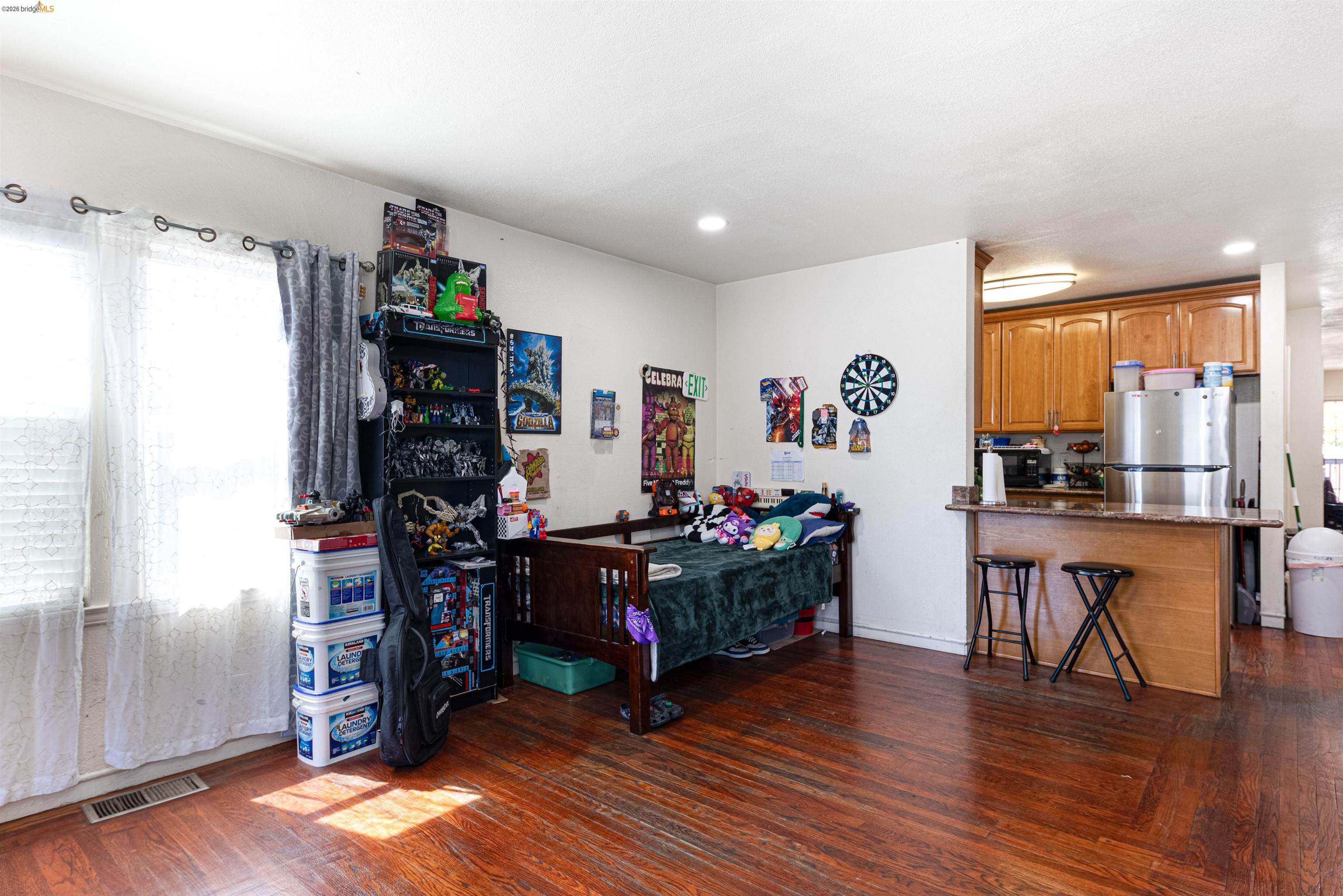 1821 74th Avenue Oakland, CA 94621 - Photo 5 of 27 Bedroom with dark wood-type flooring, freestanding refrigerator, and recessed lighting