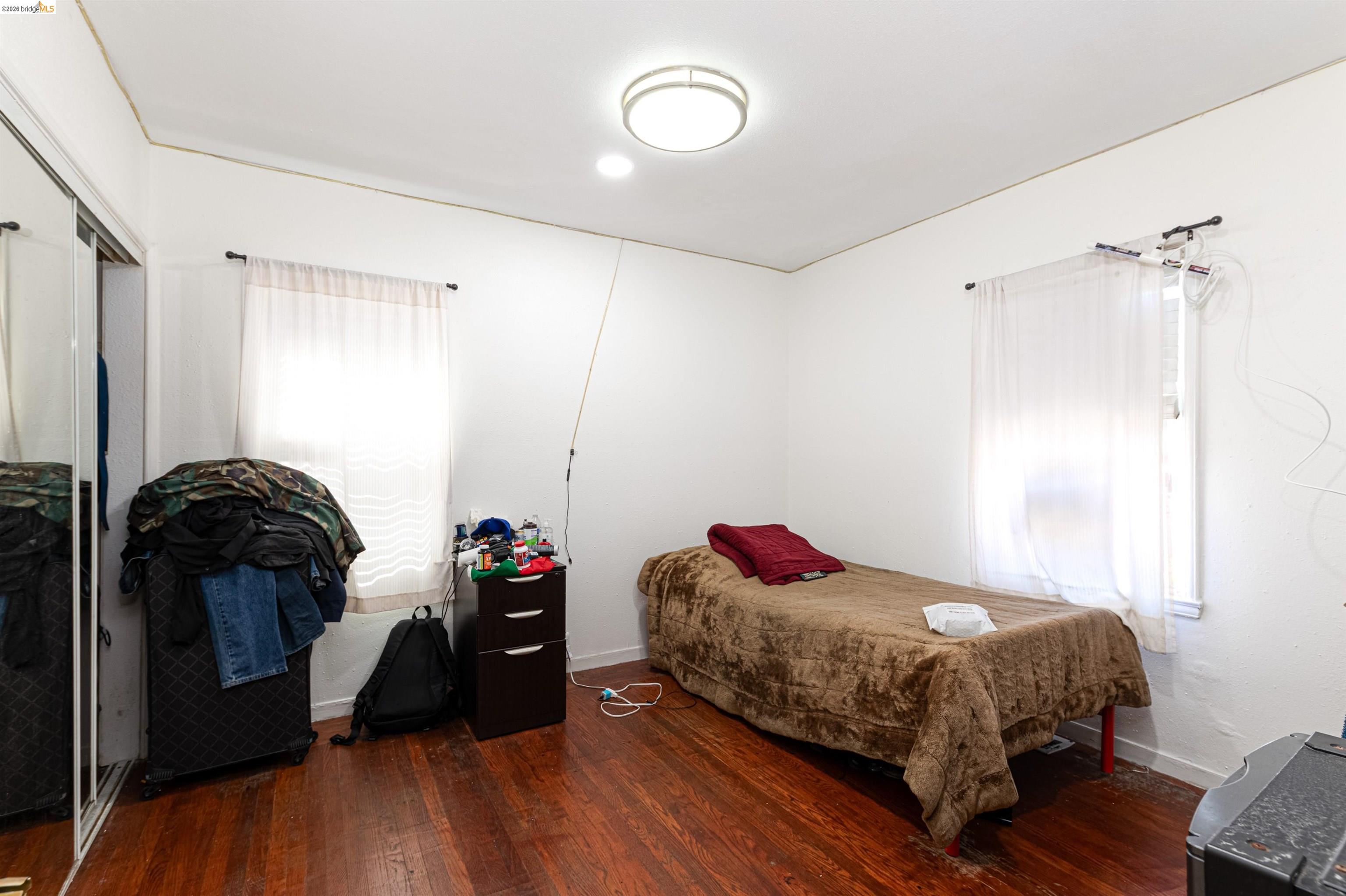 1821 74th Avenue Oakland, CA 94621 - Photo 10 of 27 Bedroom featuring dark wood-style flooring and a closet