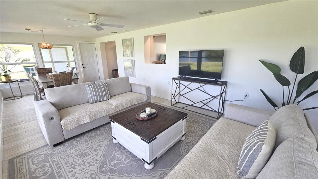 1210 Maryknoll Road Englewood, FL 34223 - Photo 19 of 37 a living room with furniture and a flat screen tv