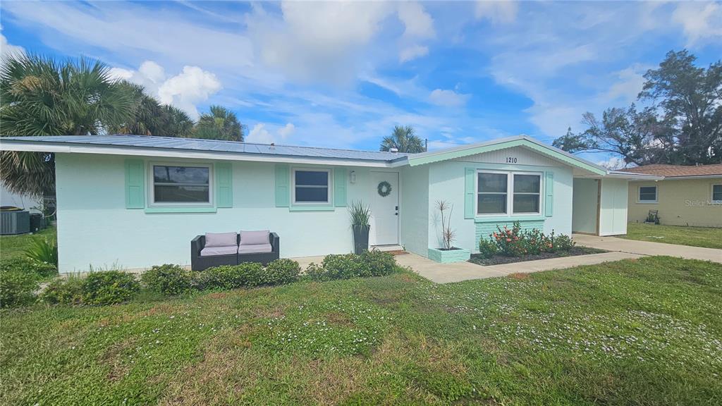 1210 Maryknoll Road Englewood, FL 34223 - Photo 2 of 37 a front view of a house with a yard