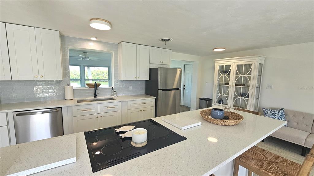 1210 Maryknoll Road Englewood, FL 34223 - Photo 6 of 37 a kitchen with a refrigerator a stove a sink and dining table