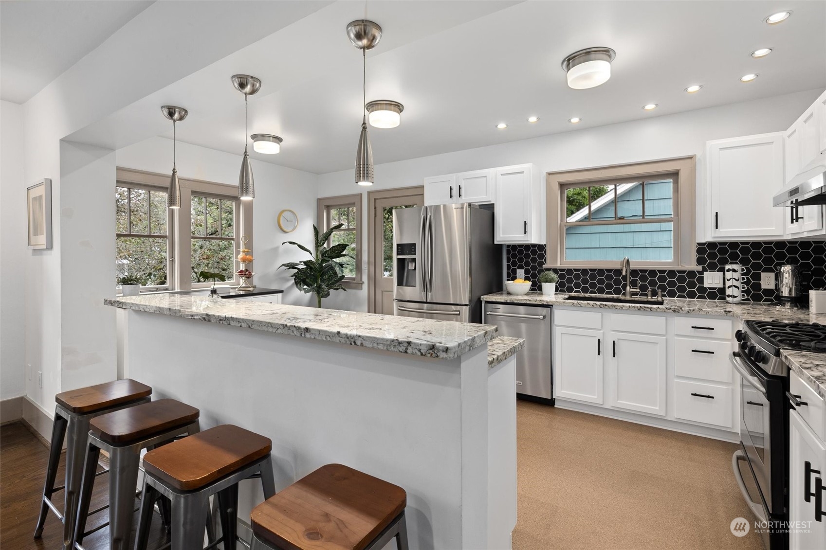 5916 8th Avenue Northeast Seattle, WA 98105 - Photo 11 of 40 a kitchen with stainless steel appliances kitchen island granite countertop a stove a sink and a refrigerator
