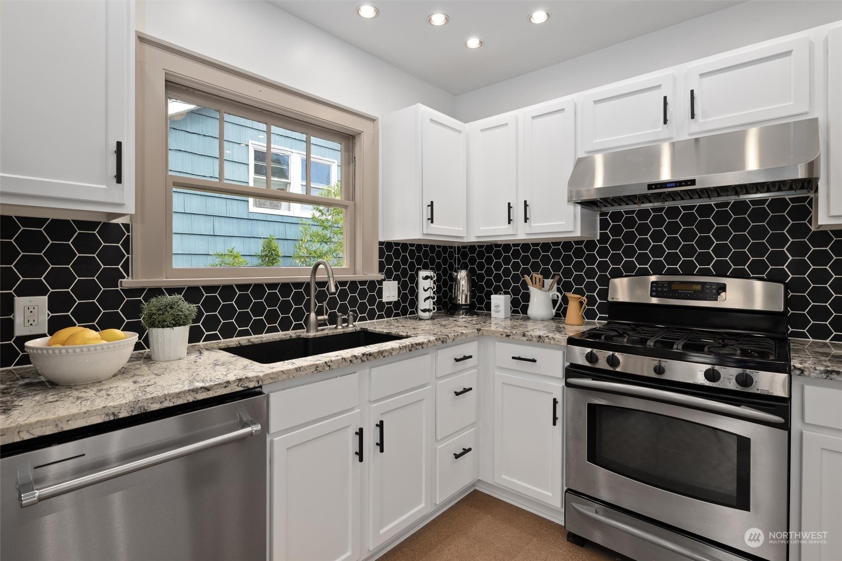 5916 8th Avenue Northeast Seattle, WA 98105 - Photo 15 of 40 a kitchen with granite countertop a stove a sink dishwasher and cabinets with wooden floor