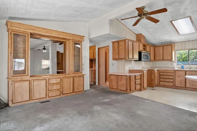 a kitchen with stainless steel appliances a sink cabinets and a window