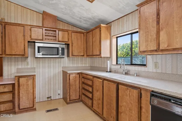 a kitchen with stainless steel appliances a stove a sink and a microwave