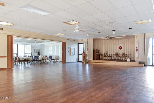 a very nice looking living room with a large window and dining table