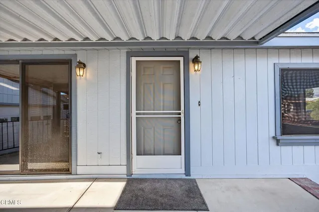 an empty room with windows and chandelier fan