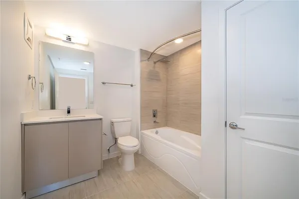 a bathroom with a bathtub shower sink vanity and toilet