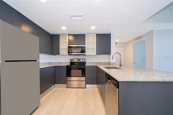 a kitchen with kitchen island granite countertop stainless steel appliances and a sink